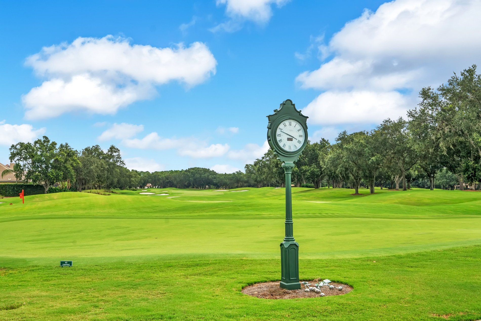 Clock overlooking a green fairway at Keene’s Pointe